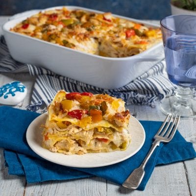 Lasagne di pollo con sfoglia a vista, strati di besciamella, peperoni rossi e gialli gratinati in superficie