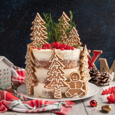 Naked cake al pan di zenzero decorata con biscotti a forma di albero, omino e bacche rosse