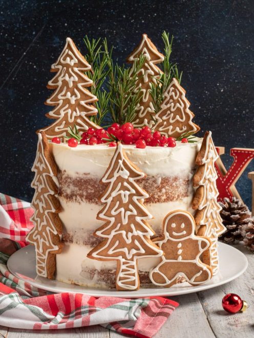 Naked cake al pan di zenzero decorata con biscotti a forma di albero, omino e bacche rosse