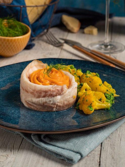 Turbante di orata ripieno di crema di carote e guarnito con finocchietto, servito con cavolfiore giallo saltato