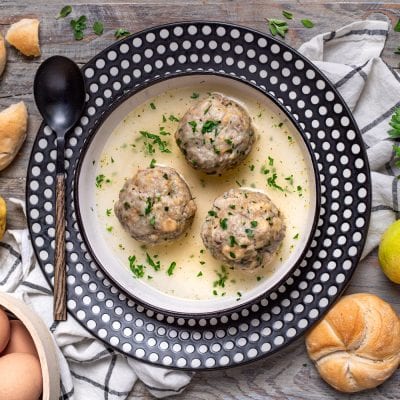 Canederli di fegato in brodo caldo, cosparsi di prezzemolo tritato fresco