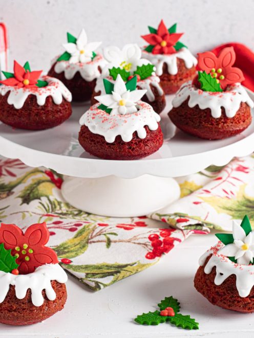 Mini red velvet bundt cake glassati di bianco e decorati con fiori di pasta di zucchero natalizi