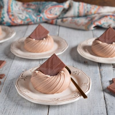 Panna cotta al gianduia a forma di ciambella con perle bianche e quadratino di cioccolato