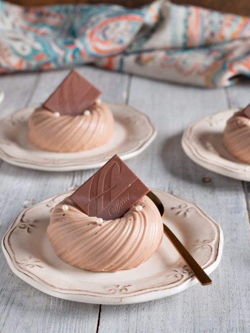 Panna cotta al gianduia a forma di ciambella con perle bianche e quadratino di cioccolato
