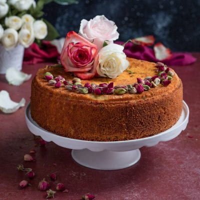 Persian love cake decorata con boccioli di rosa, pistacchi sgusciati e rose fresche in cima