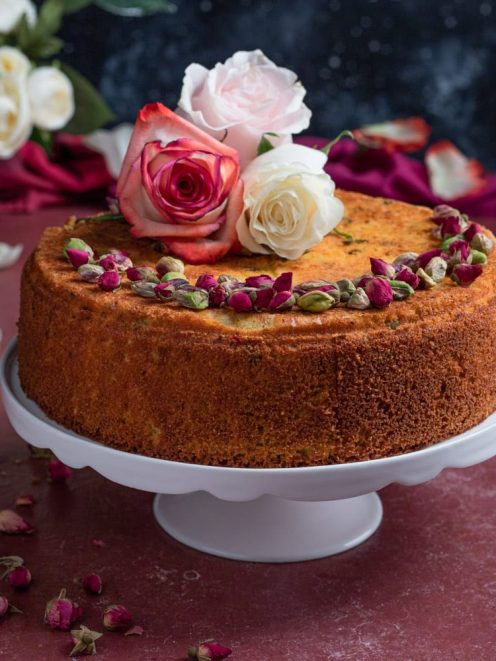 Persian love cake decorata con boccioli di rosa, pistacchi sgusciati e rose fresche in cima
