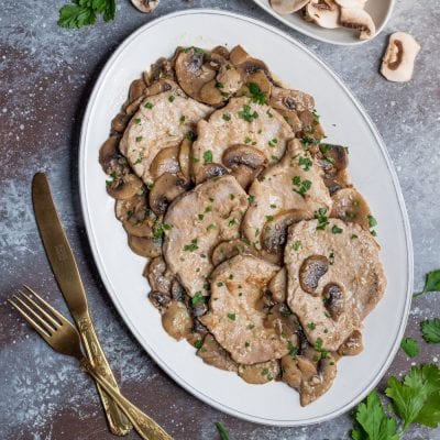 Scaloppine ai funghi con salsa cremosa, funghi champignon e prezzemolo tritato