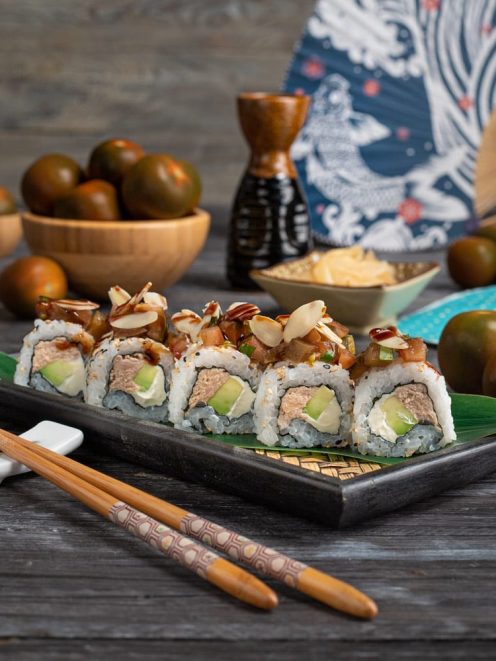 Uramaki con tonno, avocado e formaggio cremoso, guarniti con mandorle a lamelle e tartare piccante