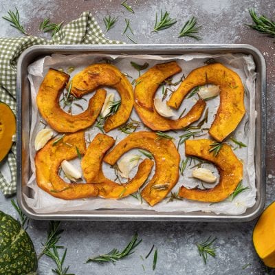 Zucca al forno a fette con aglio e rosmarino su carta da forno