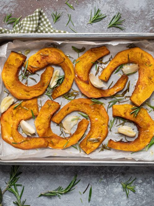 Zucca al forno a fette con aglio e rosmarino su carta da forno
