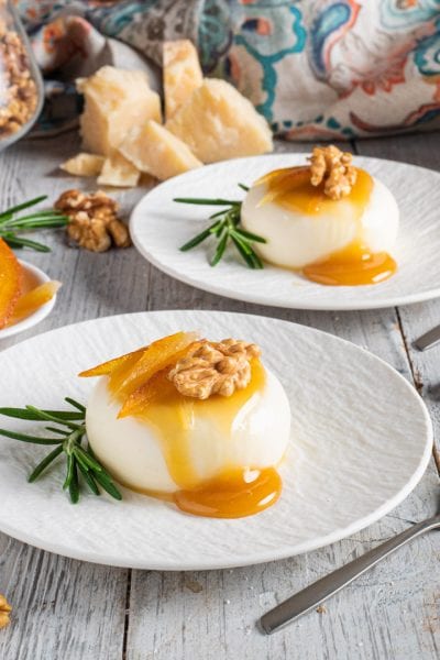Panna cotta salata con colatura al miele, gherigli di noce e scorze d'arancia candite su rametti di rosmarino