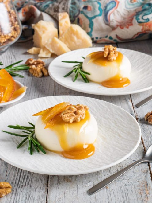 Panna cotta salata con colatura al miele, gherigli di noce e scorze d'arancia candite su rametti di rosmarino