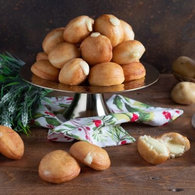 Mini krapfen salati fritti ripieni di fonduta di formaggio, uno spaccato mostra il cuore cremoso