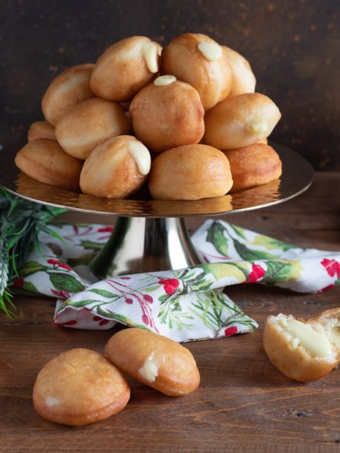 Mini krapfen salati fritti ripieni di fonduta di formaggio, uno spaccato mostra il cuore cremoso