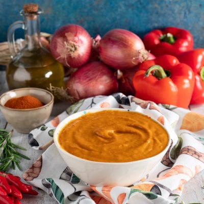 Salsa ai peperoni densa e vellutata, con cipolle rosse e peperoni freschi sullo sfondo