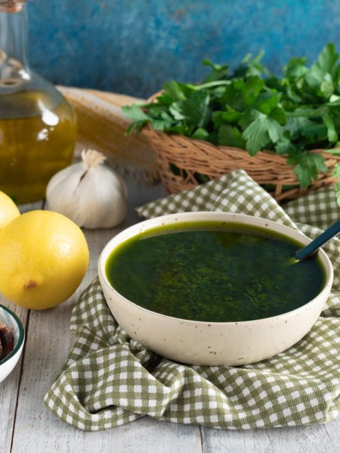 Salsa al prezzemolo densa e brillante servita con limoni, aglio e acciughe accanto