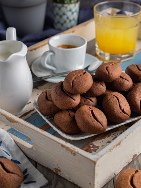 Biscotti chicco di caffè al cacao impilati su un piatto, con la caratteristica forma a chicco