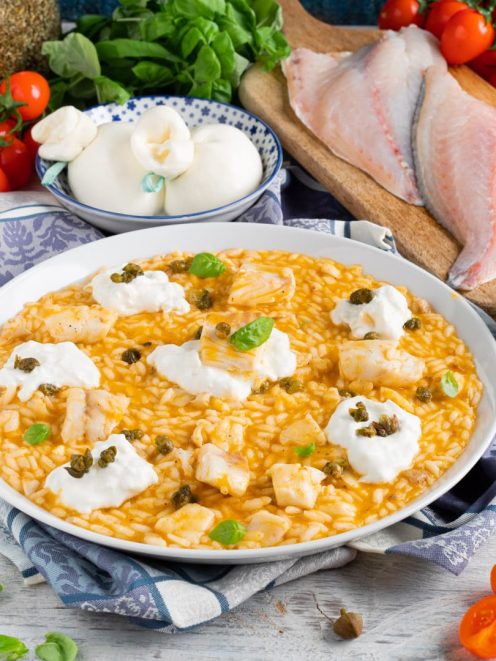 Risotto al pomodoro con orata, ciuffi di burrata, capperi e foglie di basilico fresco