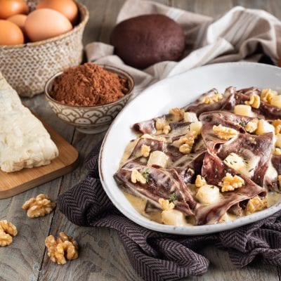 Straccetti di pasta fresca al cacao con salsa cremosa, noci e cubetti di formaggio