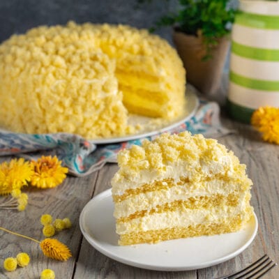 Torta Mimosa con strati di pan di Spagna e crema chantilly, ricoperta di briciole dorate