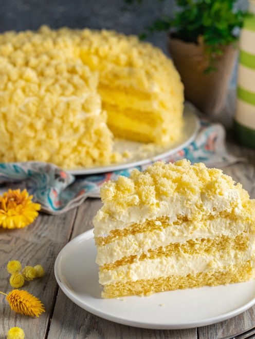 Torta Mimosa con strati di pan di Spagna e crema chantilly, ricoperta di briciole dorate
