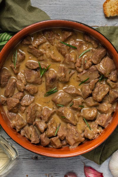 Agnello cacio e ova in tegame di coccio con sugo cremoso e rosmarino fresco