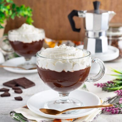 Barbajada servita in tazza trasparente con abbondante panna montata sopra la crema al cioccolato