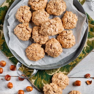 Brutti ma buoni alle nocciole appena sfornati, con nocciole sgusciate sparse intorno