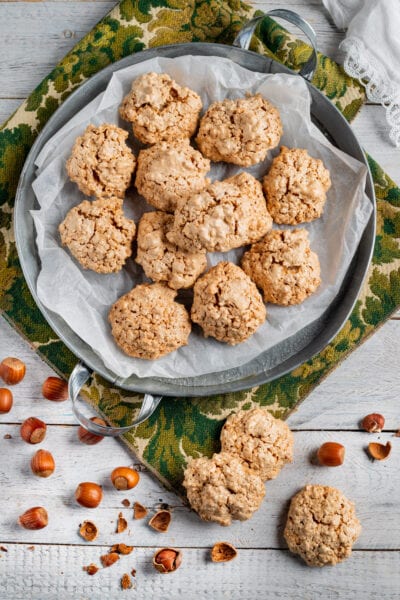Brutti ma buoni alle nocciole appena sfornati, con nocciole sgusciate sparse intorno
