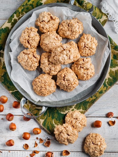 Brutti ma buoni alle nocciole appena sfornati, con nocciole sgusciate sparse intorno
