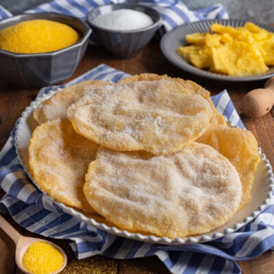 Cresciole frittelle di polenta fritte e cosparse di zucchero semolato, servite in abbondanza