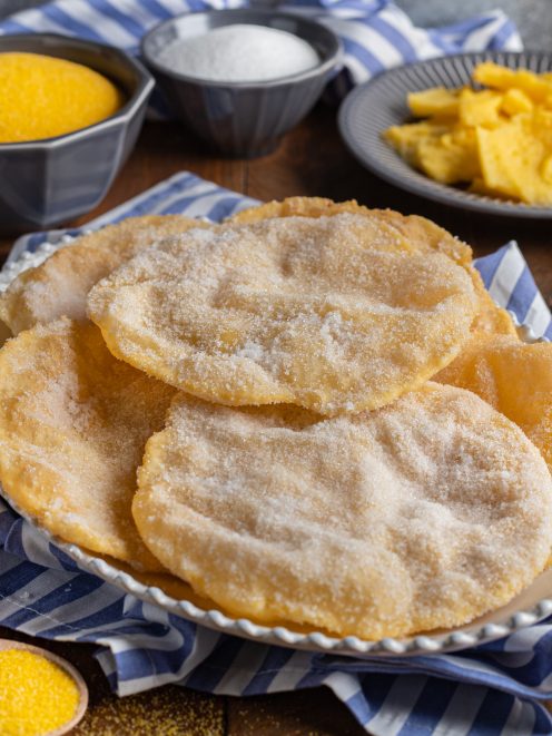 Cresciole frittelle di polenta fritte e cosparse di zucchero semolato, servite in abbondanza