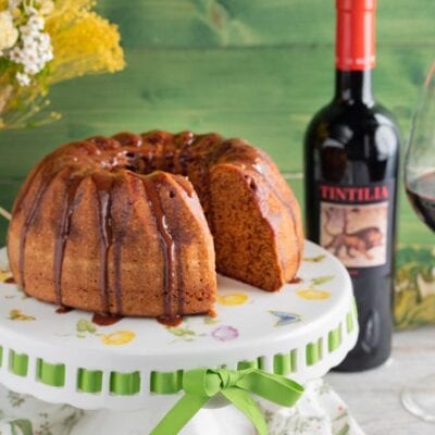 Torta alla Tintilia con glassa al vino rosso colante, una fetta tagliata mostra l'interno soffice