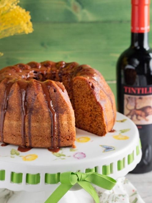 Torta alla Tintilia con glassa al vino rosso colante, una fetta tagliata mostra l'interno soffice
