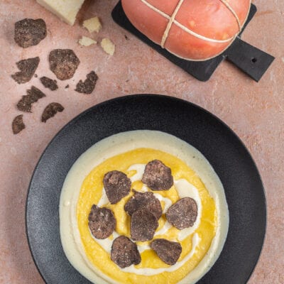Raviolone ripieno su crema di formaggio con lamelle di tartufo nero