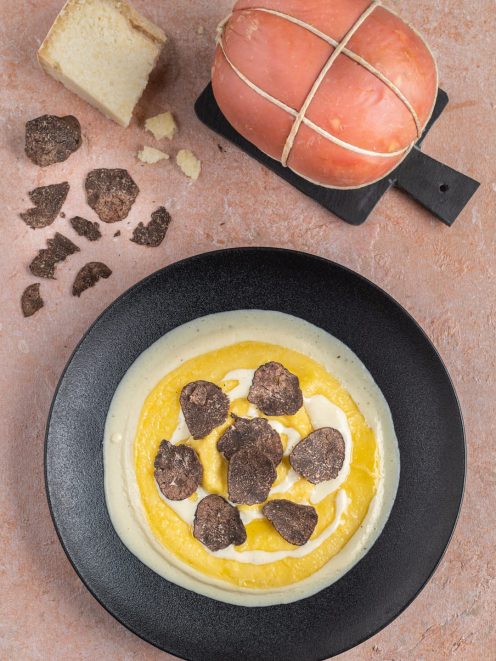 Raviolone ripieno su crema di formaggio con lamelle di tartufo nero
