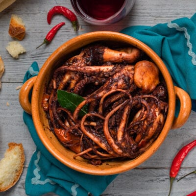 Moscardini al Cannonau in tegame di terracotta con sugo scuro, foglia di alloro e peperoncino