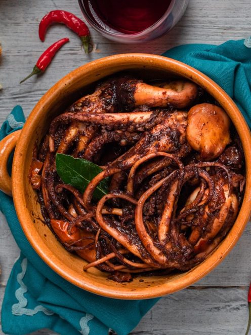 Moscardini al Cannonau in tegame di terracotta con sugo scuro, foglia di alloro e peperoncino