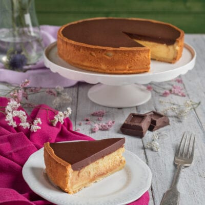 Torta Susanna con base soffice, crema chiara e glassa al cioccolato fondente, servita a fetta