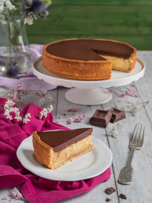 Torta Susanna con base soffice, crema chiara e glassa al cioccolato fondente, servita a fetta