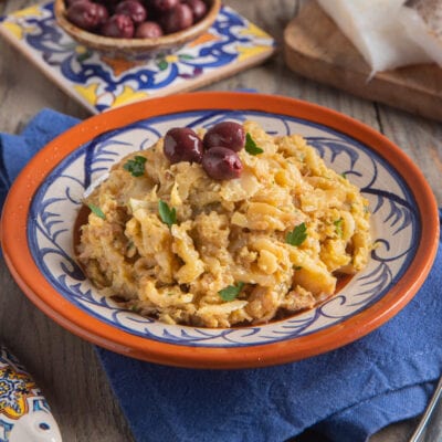 Bacalhau à Brás sfogliato con cipolle, uova e olive nere, guarnito con prezzemolo fresco