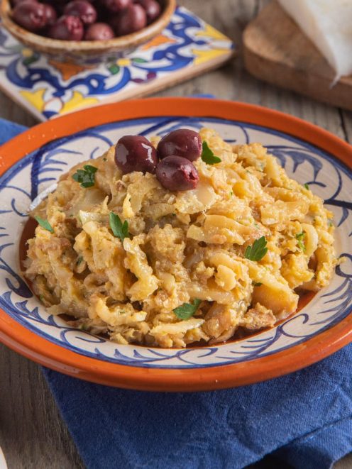 Bacalhau à Brás sfogliato con cipolle, uova e olive nere, guarnito con prezzemolo fresco