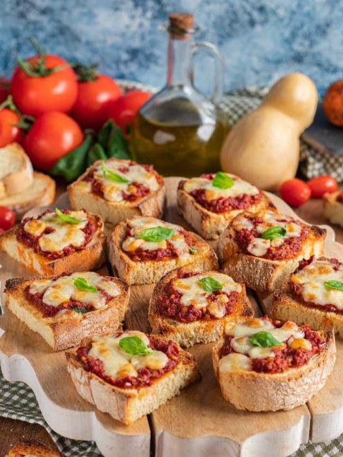 Crostini alla calabrese con salsa di pomodoro, mozzarella filante e foglie di basilico fresco