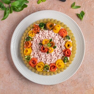 Crostata di mousse di mortadella con base verde, crema a spuntoni e roselline di verdure grigliate