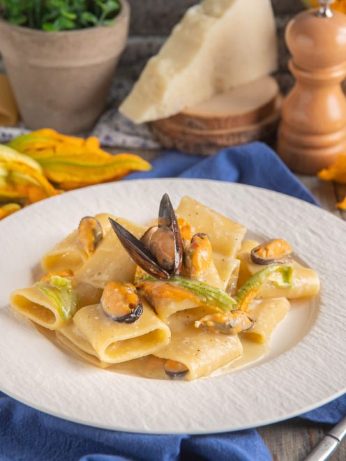 Paccheri cacio e pepe con cozze aperte e fiori di zucca in salsa cremosa