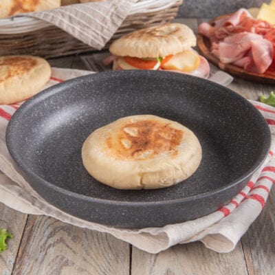 Pane palloncino appena cotto in padella, con superficie dorata e leggermente gonfia