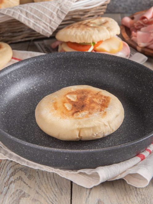 Pane palloncino appena cotto in padella, con superficie dorata e leggermente gonfia