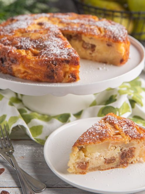 Torta di San Orfeo con mele e uvetta, spolverata di zucchero a velo, con una fetta servita in primo piano