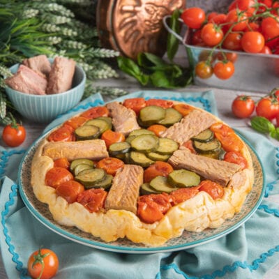 Torta rovesciata al tonno con pomodorini, zucchine a rondelle e strisce di tonno su pasta dorata