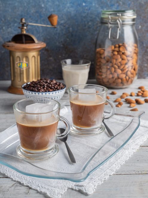 Caffè leccese servito in due bicchieri con cubetti di ghiaccio e latte di mandorla